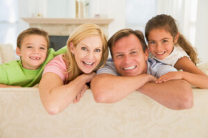 Family sitting in living room smiling